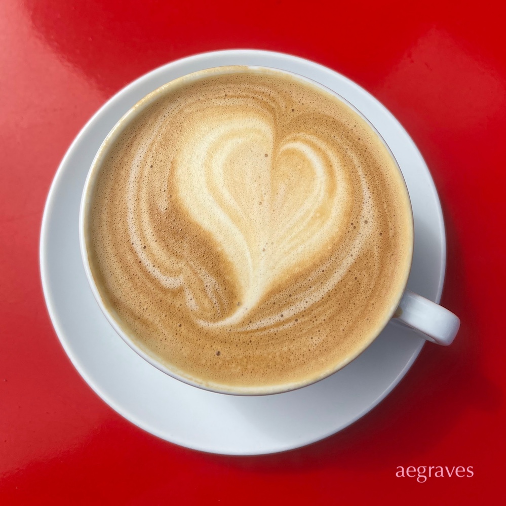 latte with a foam heart on a red background