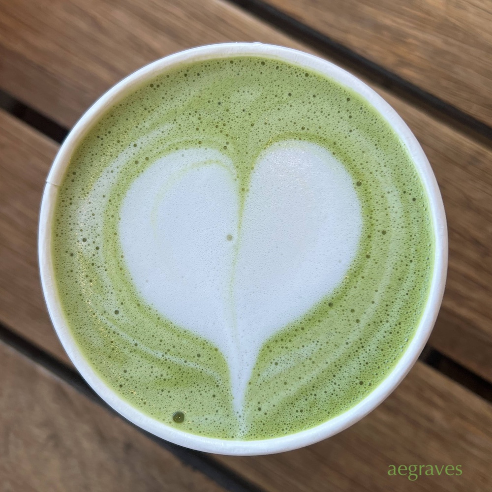 top view of a matcha latte featuring a foam heart