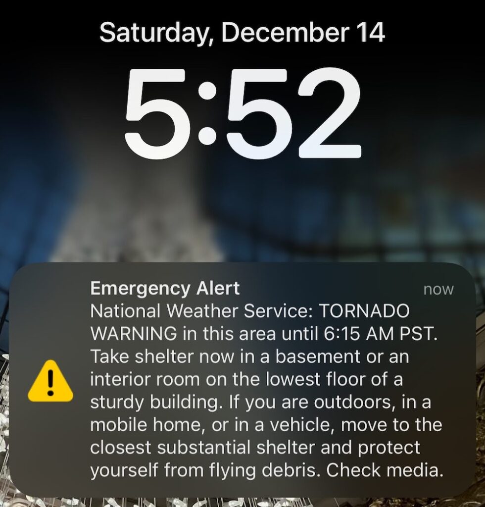 iPhone screenshot from 5:52 AM on Saturday, December 14th with the text of a National Weather Service TORNADO WARNING: "Emergecy Alert: National Weather Service: TORNADO WARNING in this area until 6:15 AM PST.  Take shelter now in a basement or an interior room on the lowest floor of a sturdy building.  If you are outdoors, in a mobile home, or in a vehicle, move to the closest substantial shter and protect yourself from flying debris.  Check media."