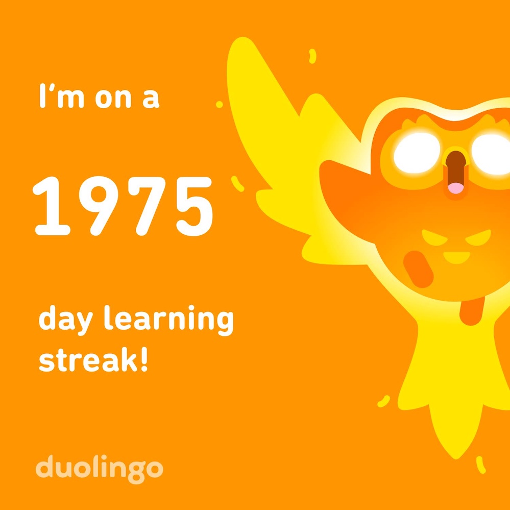 Duolingo orange and gold graphic that reads, "I'm on a 1975 day learning streak!" with the Duolingo Owl shown with white eyes and a phoenix-like outline.