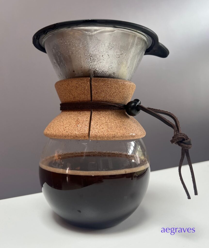 hourglass (chemex) style coffee maker brewing dark coffee