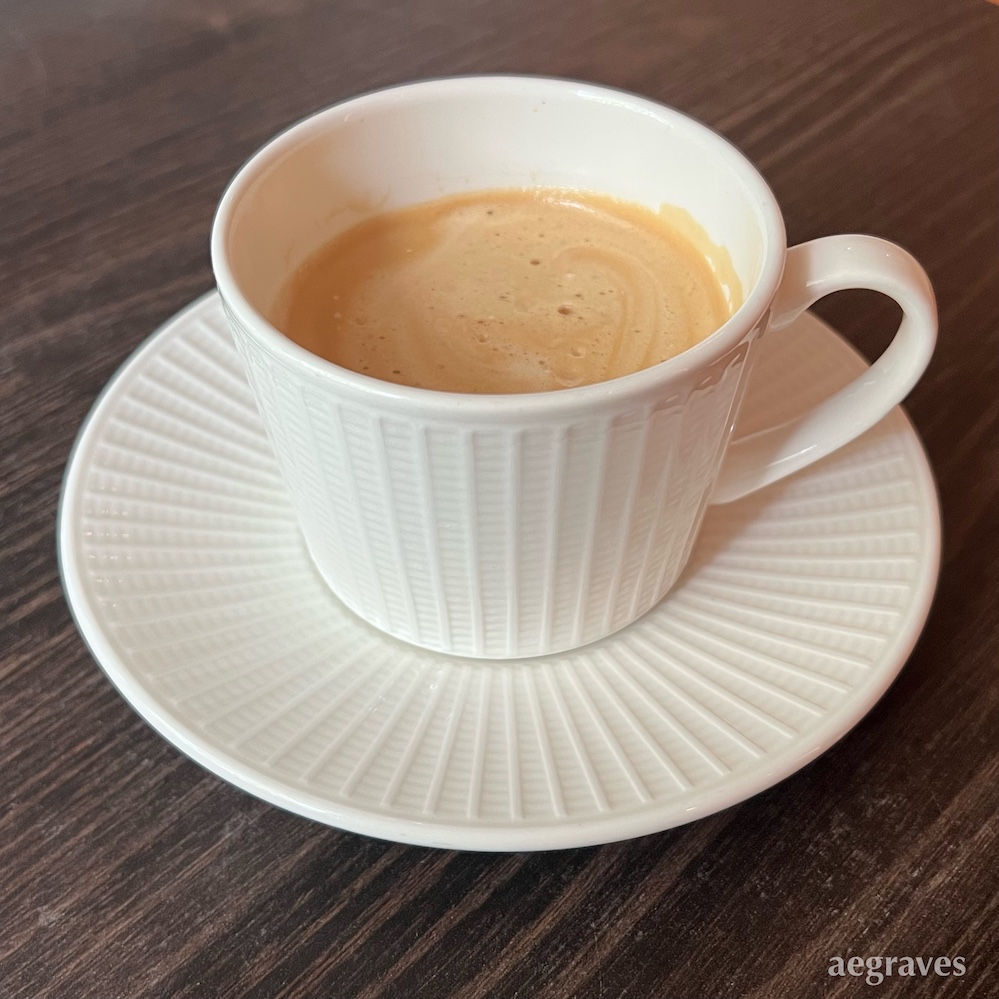 Coffee with crema in a fancy cup with saucer.